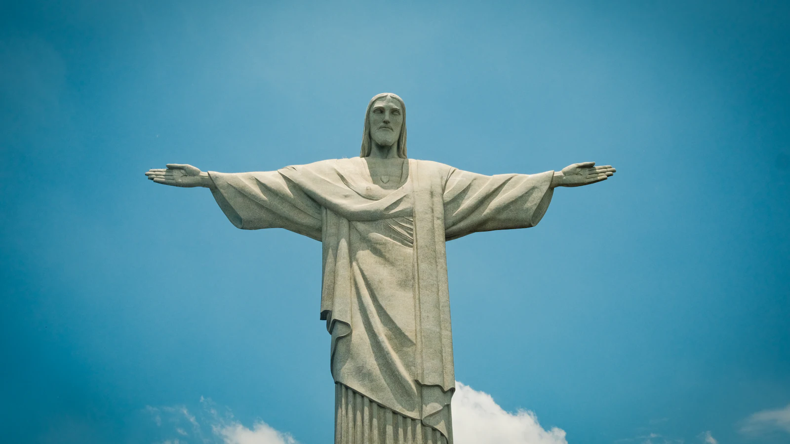 The Christ the Redeemer statue above Rio de Janeiro against a blue sky