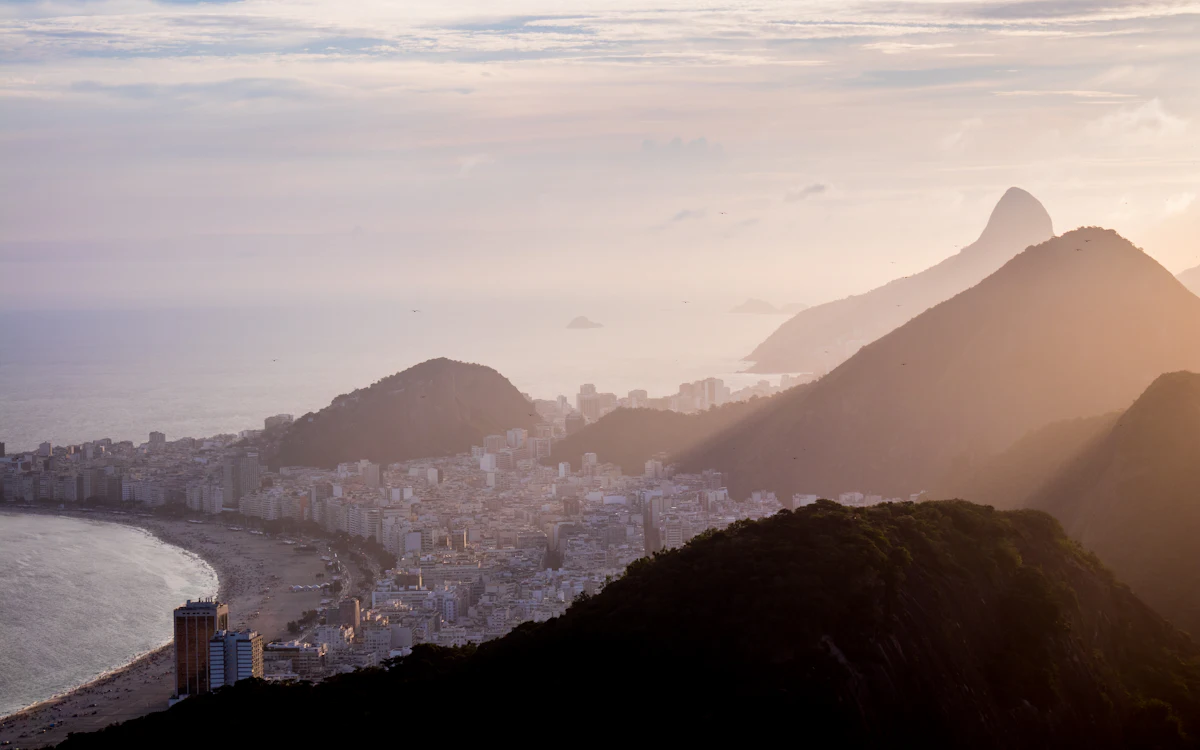 Rio de Janeiro at golden hour with the Dois Irmaos peaks in silhouette