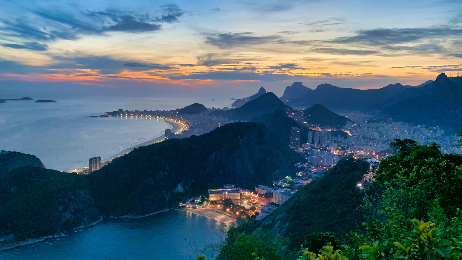 Rio de Janeiro at golden hour — the bay and granite peaks glowing at sunset